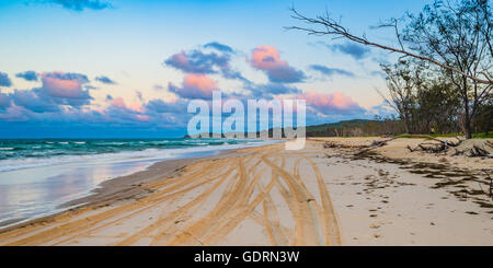 PInk clouds over North Stradbroke Island after the sun sets over the beach Stock Photo