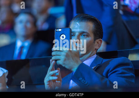 Don Trump, Jr., son of GOP Presidential candidate Donald Trump uses his phone to take a video after Senator Ted Cruz was rushed off stage by dimming the lights during his addresses on the third day of the Republican National Convention July 20, 2016 in Cleveland, Ohio. Cruz refused to endorse candidate Donald Trump. Stock Photo