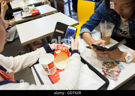 Tokyo, Japan. 22nd July, 2016. Fans try out Pokemon Go at McDonald's Shinjuku branch on July 22, 2016, Tokyo, Japan. The Pokemon Go app finally arrived in the land of the Pokemon on Friday 22, July two weeks after its launch in the United States. The release of the app in Japan had been rumoured for the past few days after the leak of details of a partnership deal with McDonald's Japan to create Pokemon Gyms in its 3,000 locations. Nintendo's market value has almost doubled since the app created by Niantic first launched in America. © Rodrigo Reyes Marin/AFLO/Alamy Live News Credit:  Aflo Co.  Stock Photo