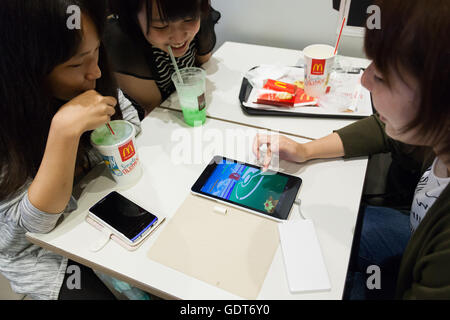 Tokyo, Japan. 22nd July, 2016. Fans try out Pokemon Go at McDonald's Shinjuku branch on July 22, 2016, Tokyo, Japan. The Pokemon Go app finally arrived in the land of the Pokemon on Friday 22, July two weeks after its launch in the United States. The release of the app in Japan had been rumoured for the past few days after the leak of details of a partnership deal with McDonald's Japan to create Pokemon Gyms in its 3,000 locations. Nintendo's market value has almost doubled since the app created by Niantic first launched in America. © Rodrigo Reyes Marin/AFLO/Alamy Live News Credit:  Aflo Co.  Stock Photo