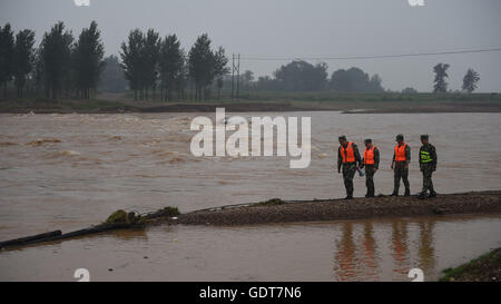 Huludao, China's Liaoning Province. 22nd July, 2016. Frontier soldiers check the water level of a river at Yulin Village, Huludao City, northeast China's Liaoning Province, July 22, 2016. Rainstorm hit the city on Wednesday and Thursday, affecting 25 towns and about 26,133 hectares of farmland. © Pan Yulong/Xinhua/Alamy Live News Stock Photo