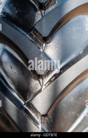 close up of large a large, black tractor tyre with big, new rubber treads, this heavyweight is powerful in appearance Stock Photo