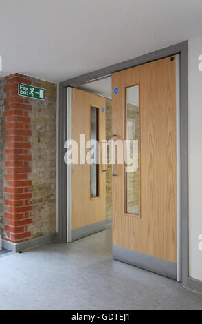 Modern fire doors in a new extension to a Victorian school. Doors adjoin original brickwork and feature latest trap-free hinges Stock Photo