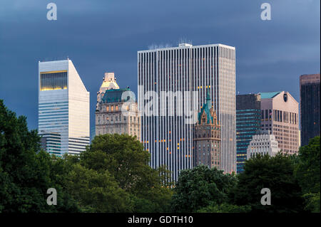 New York City buildings and skyscrapers at dusk viewed from Central Park (Manhattan Midtown) with a stormy evening sky Stock Photo