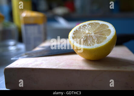 Fresh lemon slice on chopping board Stock Photo