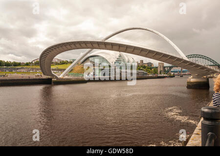 A view of the Newcastle Quayside featuring the Gateshead Millenium Bridge in its open position over the River Tyne Stock Photo