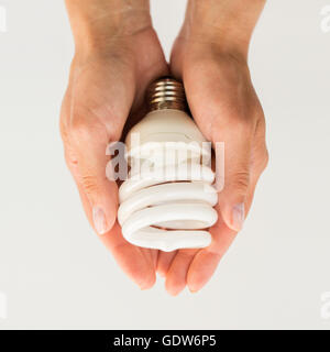 close up of hands holding energy saving lightbulb Stock Photo
