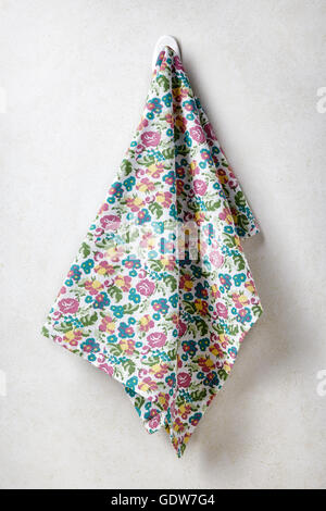 Colorful towel with flowers hanging on white concrete wall background Stock Photo