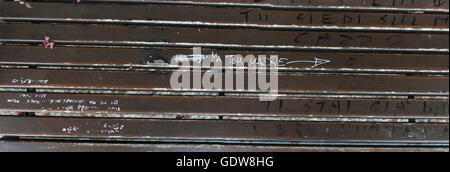 Bench coved in a, large amount of graffiti, Hastily scruffily and unprofessional, armature work, with Italian words Stock Photo