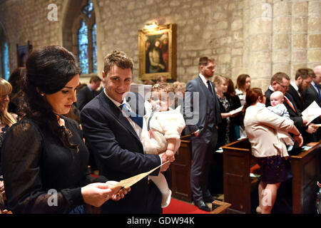 Young family in church for childs christening England Uk Stock Photo