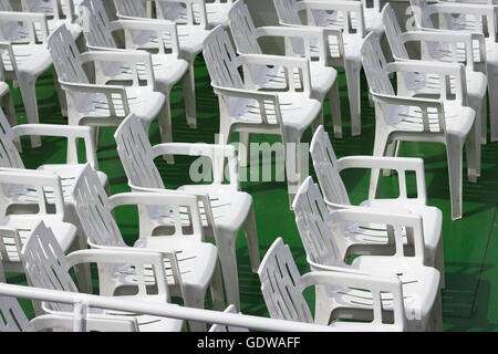 many white empty plastic chairs in rows Stock Photo