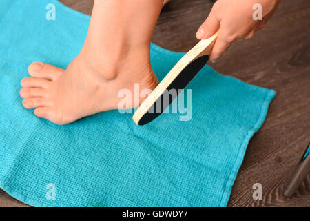 Female hand holding a foot file near her heel Stock Photo