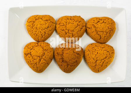 Heart shaped oatmeal cookies on white plate. Homemade breakfast cookies. Valentines Day or Mothers day sweet pastry. Stock Photo