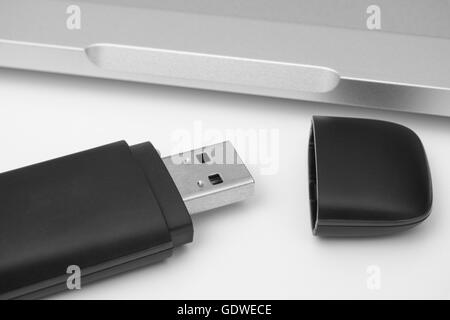 USB Flash Drive with laptop in the background. Black and white. Close up. Stock Photo