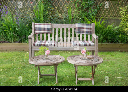 wooden bench in an english garden on a summer's day. Stock Photo