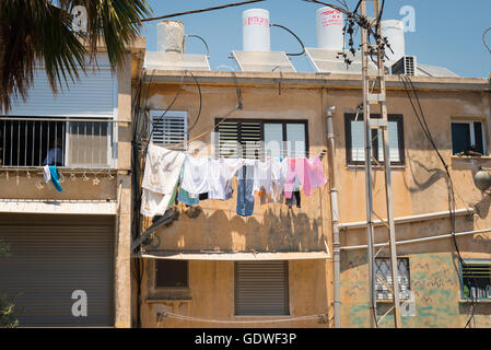 Israel Akko Acre town centre center typical street road scene washing on line by window solar panels hot water tanks on roof Stock Photo