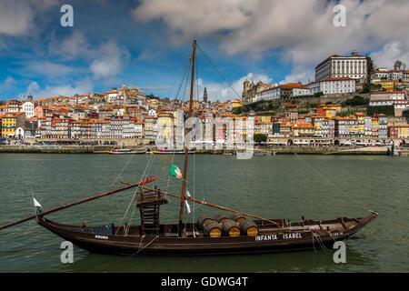 Traditional Rabelo boat designed to carry wine down Douro river with city skyline behind, Porto, Portugal Stock Photo