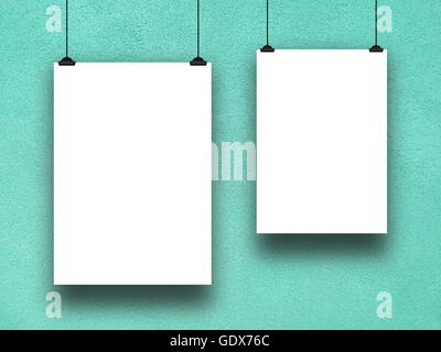 Close-up detail of two blank frames hanged by clips against aqua rough concrete wall background Stock Photo