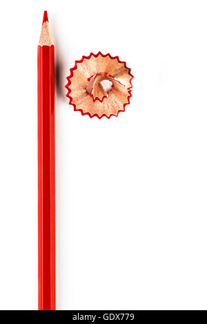 Red pencil with red shaving on white background. Vertical image. Stock Photo