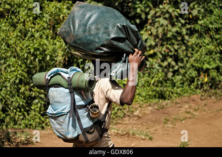 Porter carrying a backpack and another bag on his head, Mount Kilimanjaro National Park, Tanzania Stock Photo