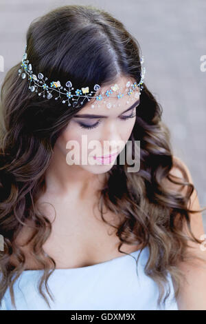 Close-up portrait of young brunette European type, with long curly hair and the decoration on the Stock Photo