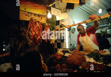 A butcher in a market offers meat for sale from his mobile ...