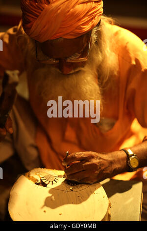 old traditional sculptor working on wood Stock Photo