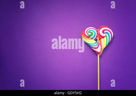 Heart shaped lollipop, isolated on violet background Stock Photo