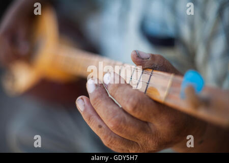 Close up shot of a man playing a Tatar instrument called 'baglama'. Stock Photo