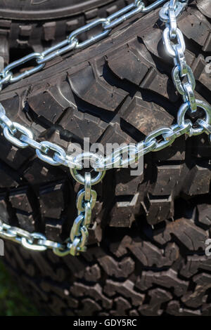 Close up shot of some chains wrapped around a car's tire. Stock Photo