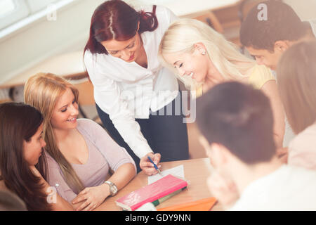 Teacher helping her students in class. Stock Photo