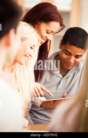 College teacher showing something to her students on a digital tablet. Stock Photo