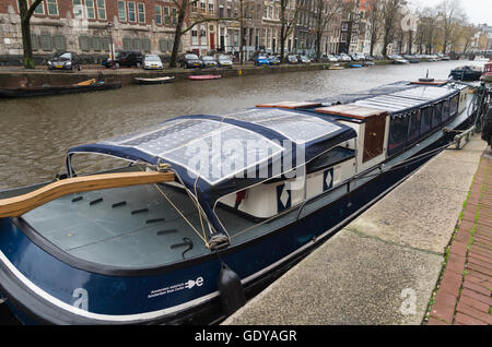 AMSTERDAM, NETHERLANDS - NOVEMBER 15, 2015: Bark with solar panels on the roof in an amsterdam canal Stock Photo