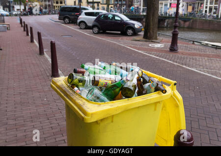 AMSTERDAM, NETHERLANDS - NOVEMBER 15, 2015: Yellow bin filled with empty bottles in the streets of amsterdam Stock Photo