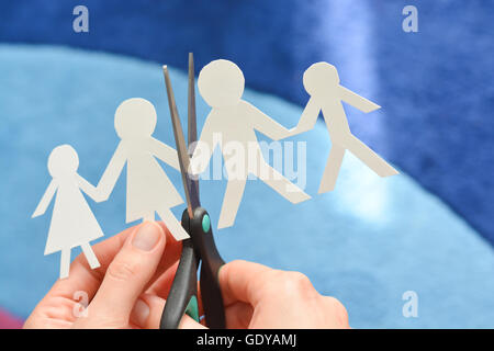 Family divorce concept with human paper shapes and scissors suggesting relationship problems Stock Photo