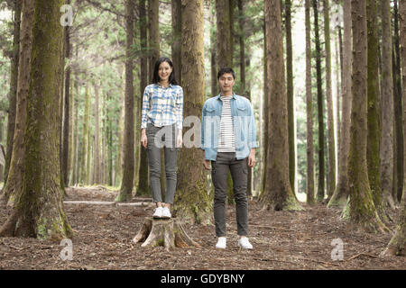 Young smiling couple standing in forest Stock Photo