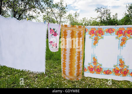Among the trees in the garden to dry on the ropes and cloths and towels. Stock Photo