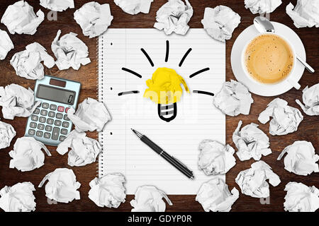 notebook on desk with light bulb idea symbol and many paper balls Stock Photo