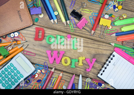 Don't Worry word and office tools on wooden table Stock Photo