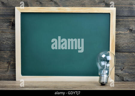 School board and bulb on wooden table Stock Photo