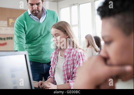 Teacher explaning something at computer in computer lab, Bavaria, Germany Stock Photo
