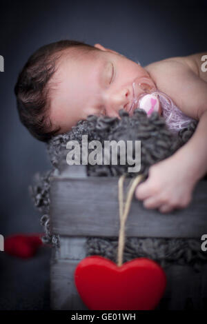 Close-up of cute newborn baby girl sleeping with pacifier on winebox, Fürstenfeldbruck, Bavaria, Germany Stock Photo