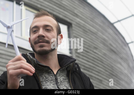 Male engineer looking at model of windmill in the city, Freiburg im breisgau, Baden-württemberg, Germany Stock Photo