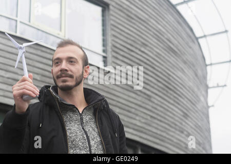 Male engineer looking at model of windmill in the city, Freiburg im breisgau, Baden-württemberg, Germany Stock Photo