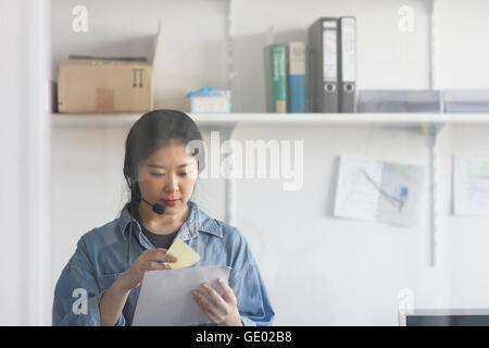 Young female engineer wearing headset and working in an industrial plant, Freiburg im Breisgau, Baden-Württemberg, Germany Stock Photo