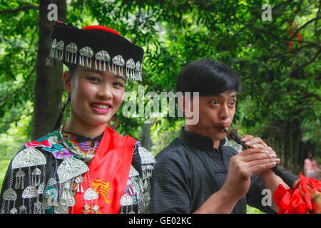Man playing flute and Miao woman smiling Stock Photo
