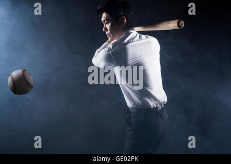 Side view of business man posing with a baseball bat Stock Photo