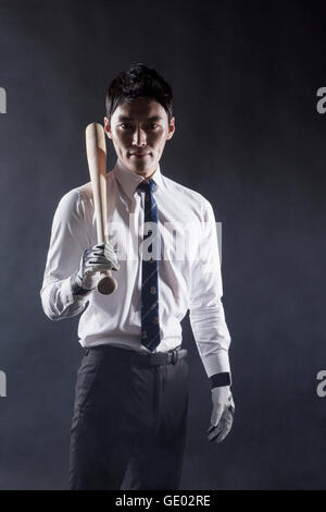 Businessman holding a baseball bat staring at front Stock Photo