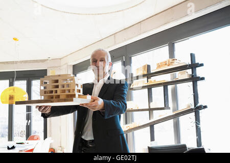 Portrait of a senior architect showing architectural model in the office, Freiburg im Breisgau, Baden-Württemberg, Germany Stock Photo