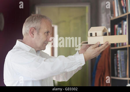 Senior architect working on model house and standing in the office, Freiburg im Breisgau, Baden-Württemberg, Germany Stock Photo